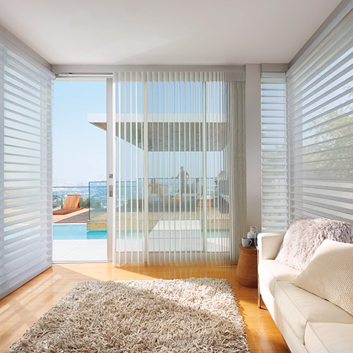 Hunter Douglas silhouette sheer shades in a cosy living room with expansive windows overlooking a poolside view.