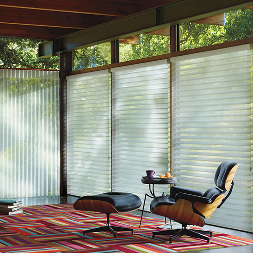 A living room with large windows featuring white Silhouette sheer shades, providing both privacy and soft, filtered light.